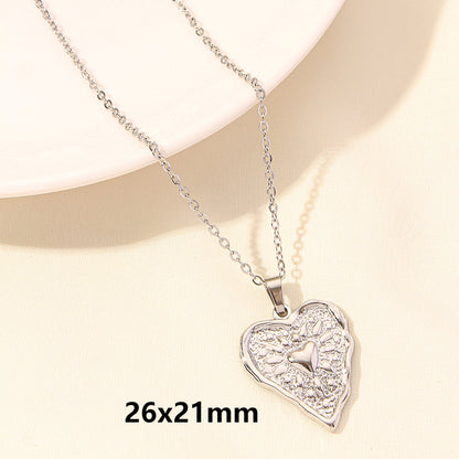 Heart-shaped silver pendant necklace on a beige background