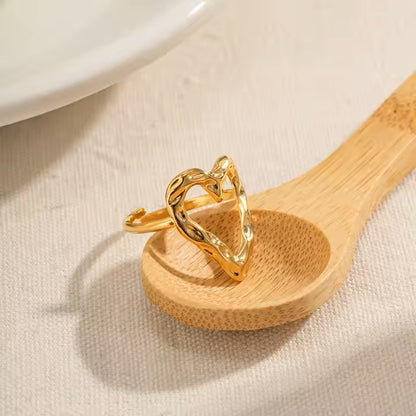 Gold ring on a wooden spoon with a neutral background