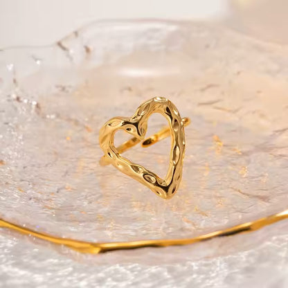 Gold heart-shaped ring on a reflective surface