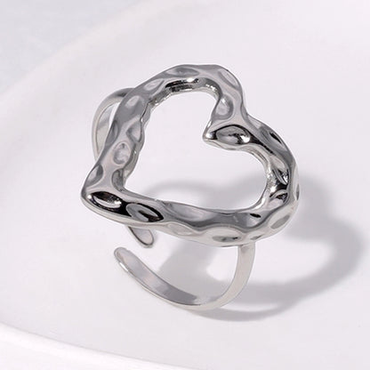 Silver heart-shaped ring on a light gray background