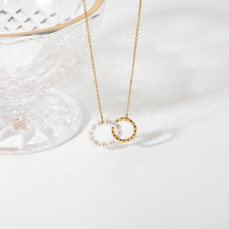 Gold necklace with a circular pendant on a white background