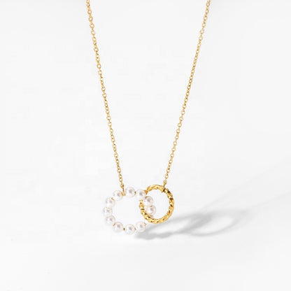 Gold necklace with a circular pendant featuring pearls on a white background