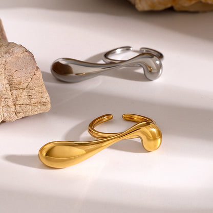 Gold and silver stainless steel statement rings on a light background