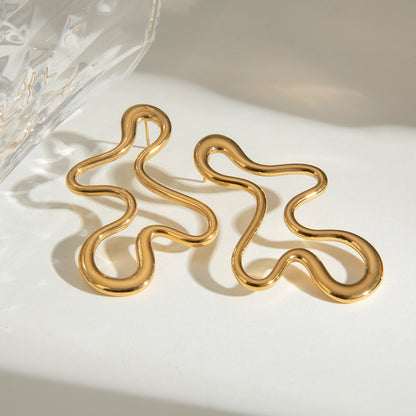 Elegant gold abstract earrings on a light background