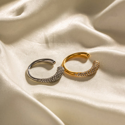Gold and silver stainless steel rings with zircones on a beige fabric background