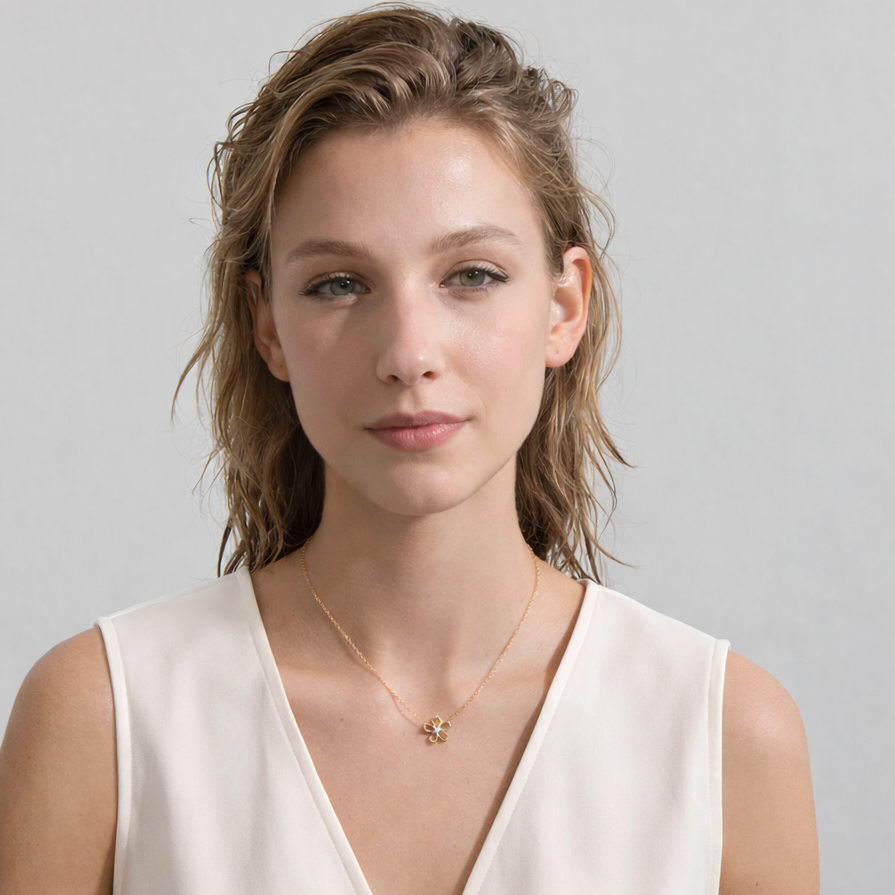 Woman wearing a gold necklace against a plain background