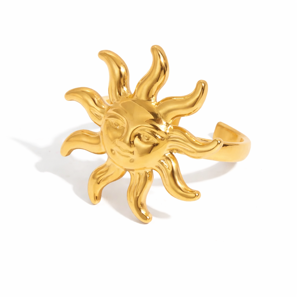 Gold sun-shaped ring on a white background