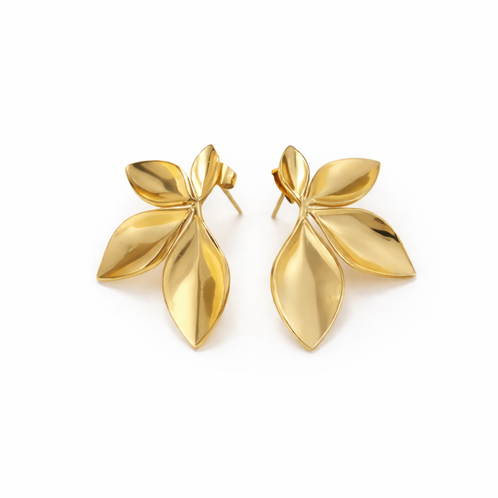 Pair of gold leaf-shaped earrings on a white background