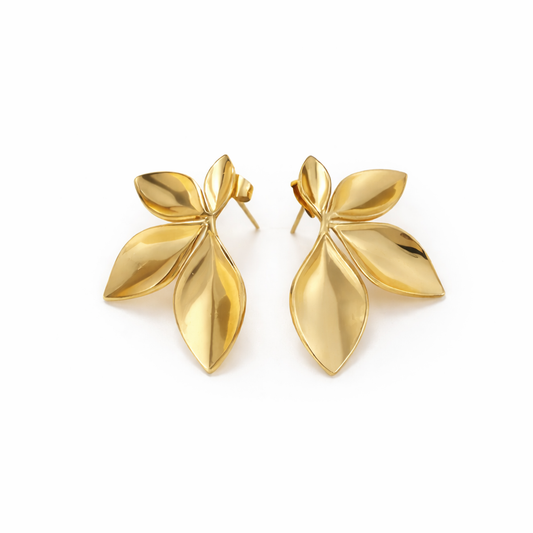 Pair of gold leaf-shaped earrings on a white background