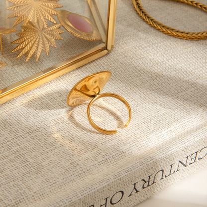 Gold ring on a textured surface with a decorative box in the background