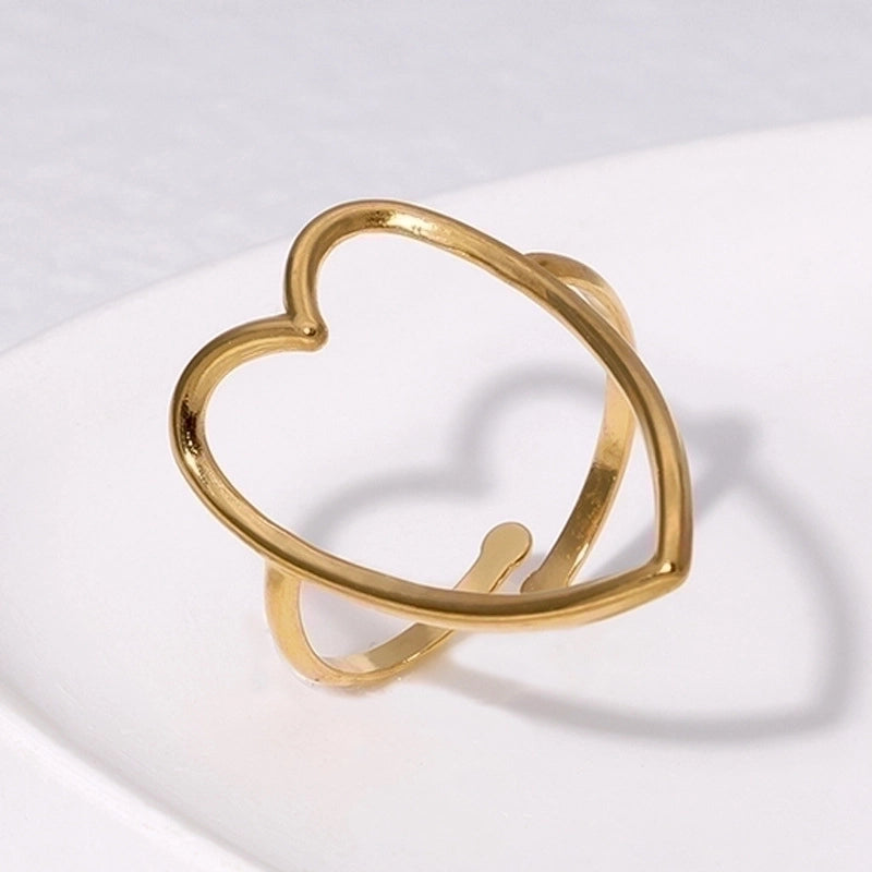 Gold heart-shaped ring on a light gray background