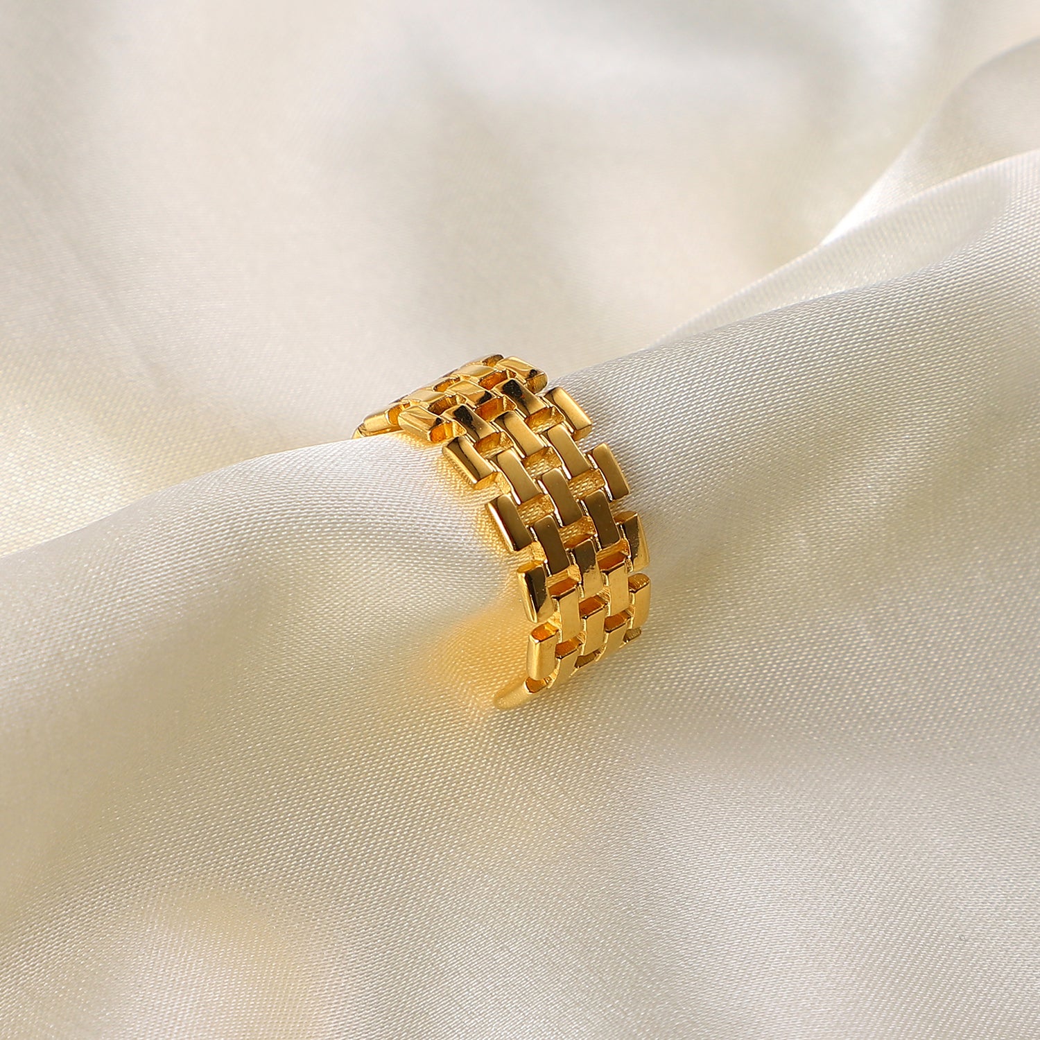 Gold stainless steel ring on a white fabric background