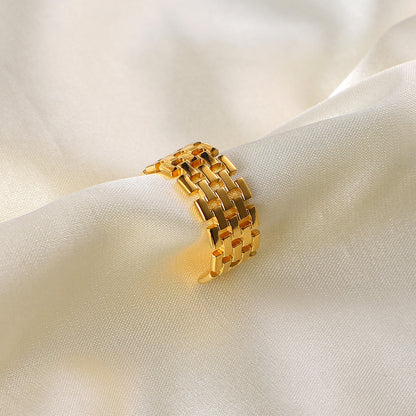 Gold stainless steel ring on a white fabric background