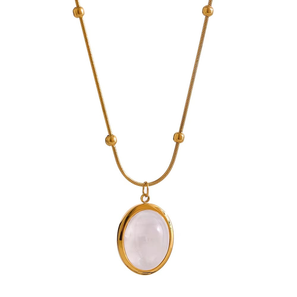 Gold necklace with a white stone pendant on a white background