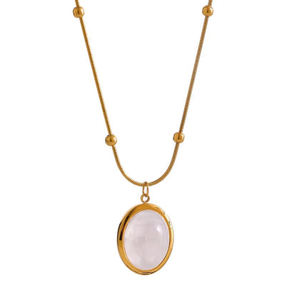 Gold necklace with a white stone pendant on a white background