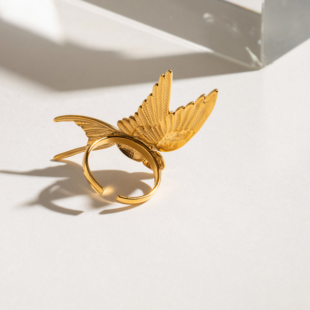 Gold leaf-shaped ring on a white surface