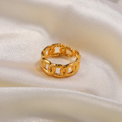 Gold chain ring on a white satin surface
