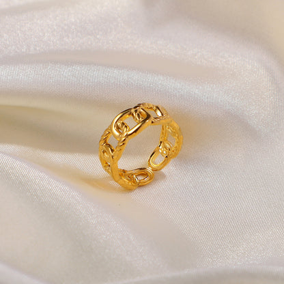 Gold chain ring on a white satin background