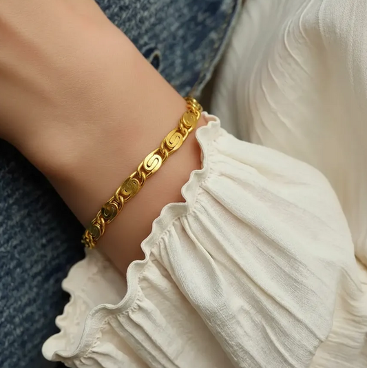 Gold bracelet on a wrist with a blurred background