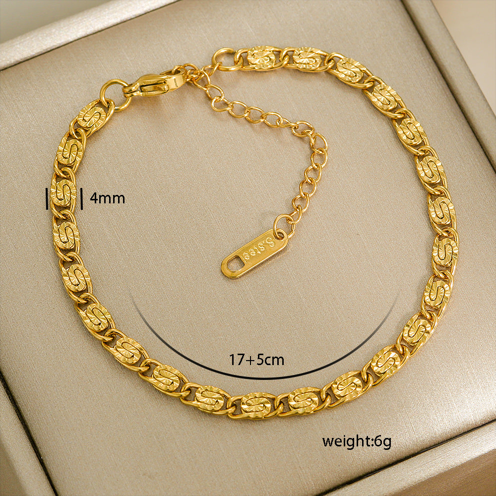 Gold chain bracelet with measurements on a beige background