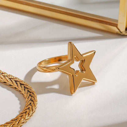 Gold star-shaped ring on a light background