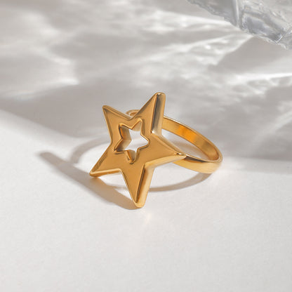 Gold star-shaped ring on a white fabric background