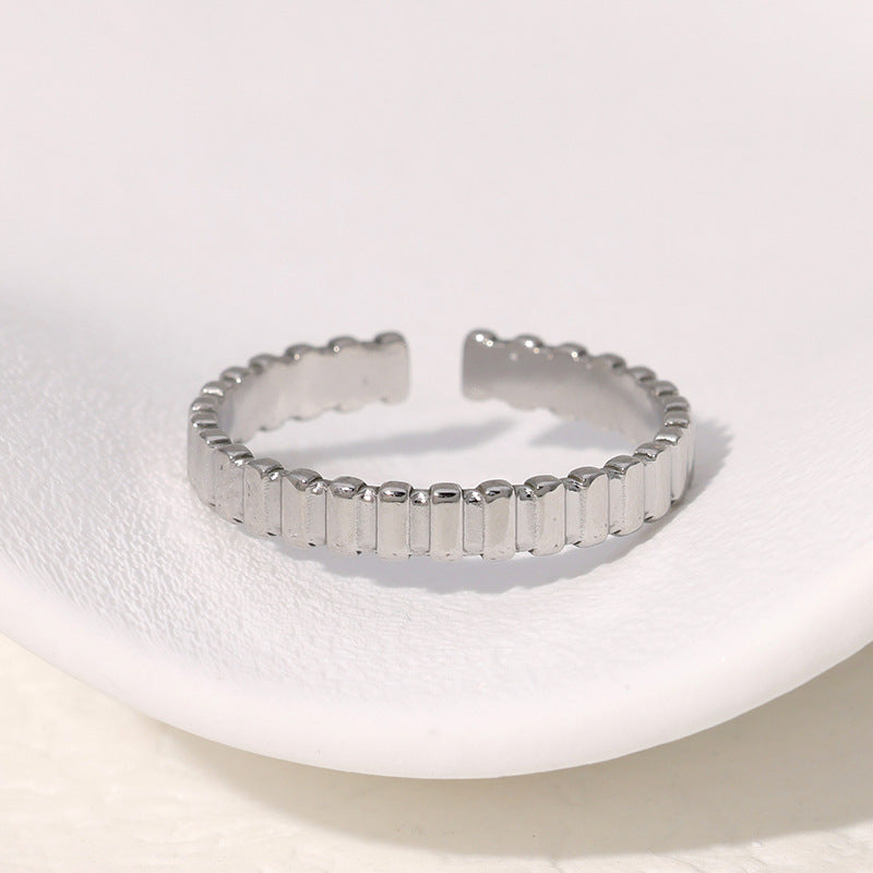 Simple silver ring with a textured band on a white background