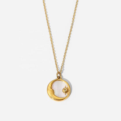 Gold necklace with a circular moon and sun pendant on a white background