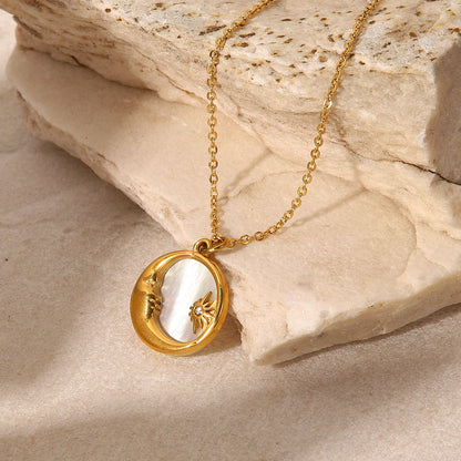 Gold necklace with a pendant on a stone surface