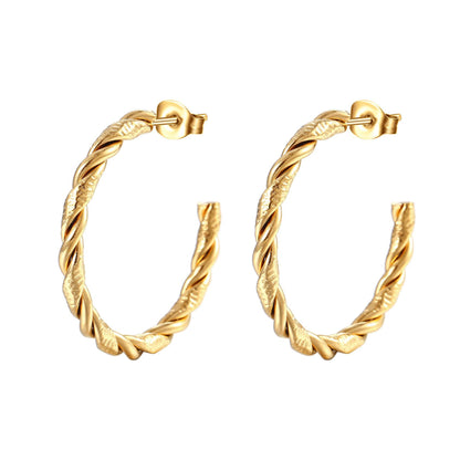 Gold hoop earrings with twisted design on a white background