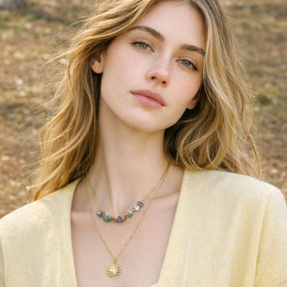 Woman wearing a necklace with a sun pendant in a natural setting