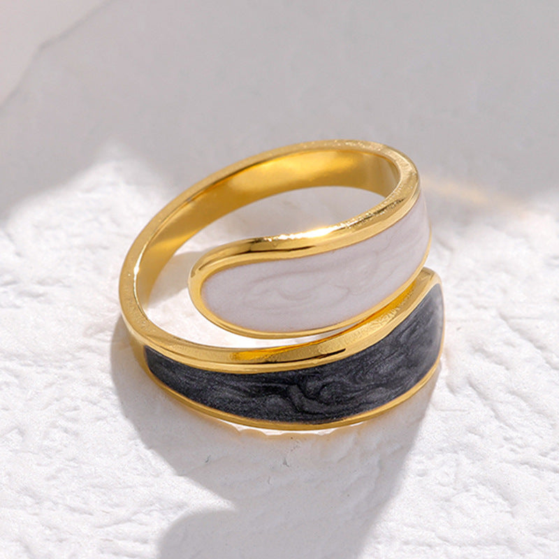 Gold and black waterproof spiral ring on a textured white surface