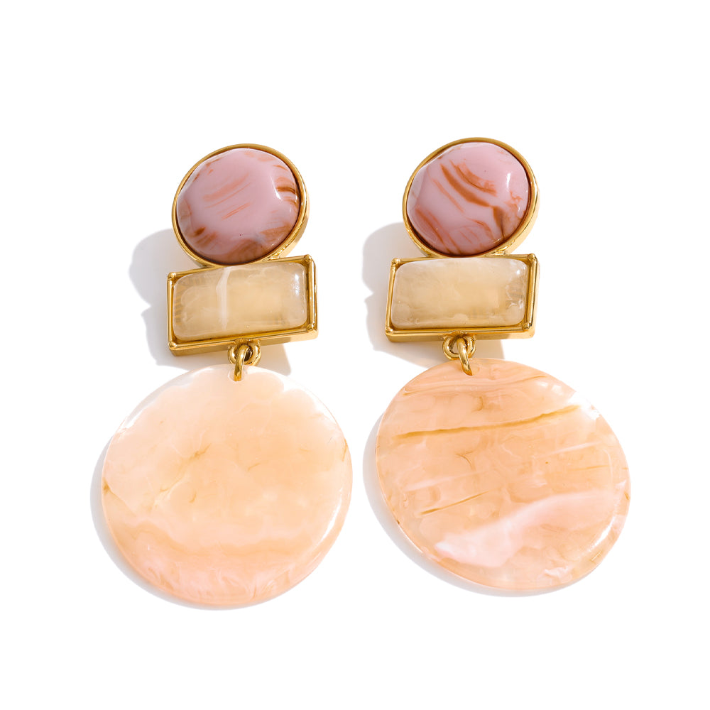 Pair of earrings with pink and beige stones on a white background