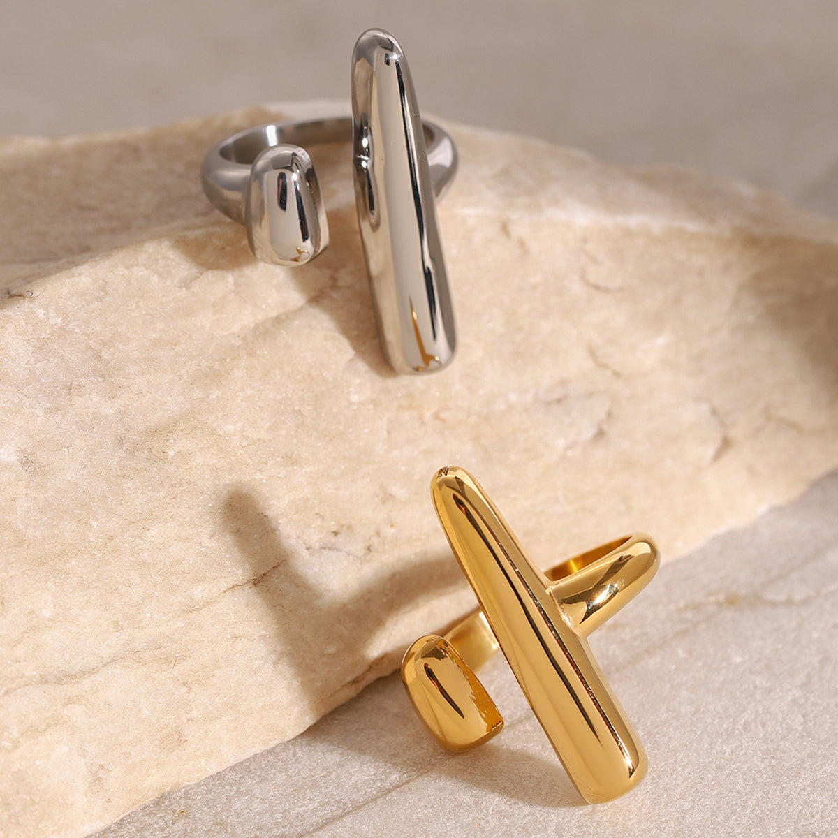 Gold and silver rings on a textured beige surface