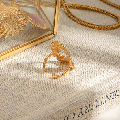 Gold ring on a textured surface with a decorative box in the background