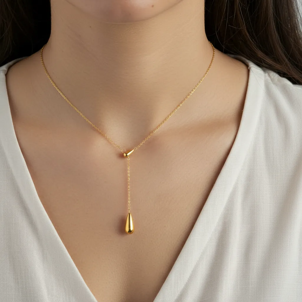 Gold stainless steel necklace with a pendant on a model wearing a white top