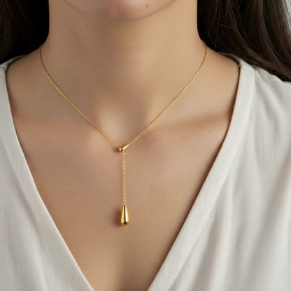 Gold stainless steel necklace with a pendant on a model wearing a white top