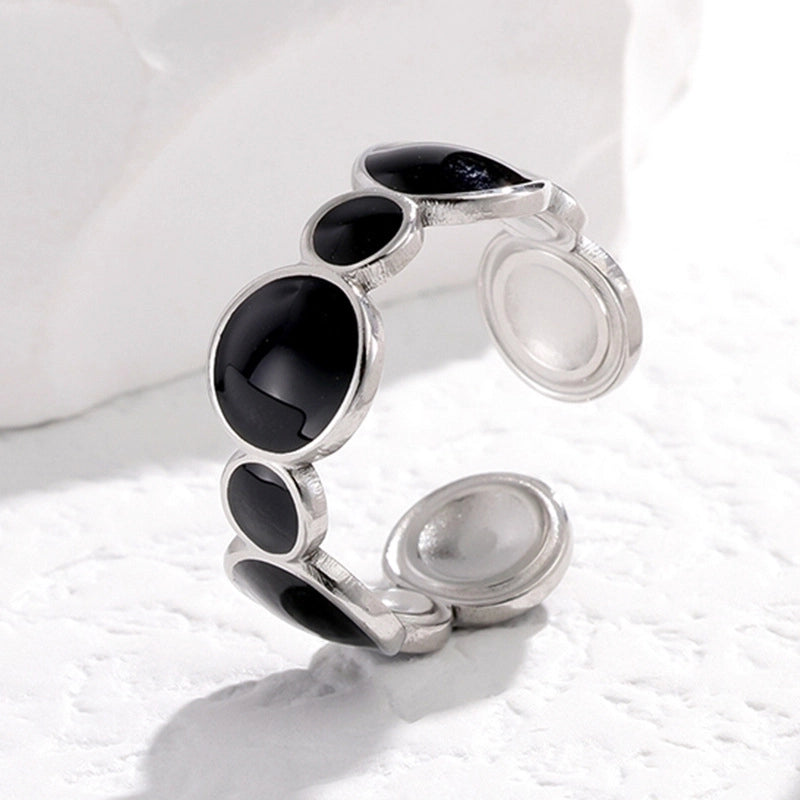 Silver tarnish-free ring with black gemstones on a white background