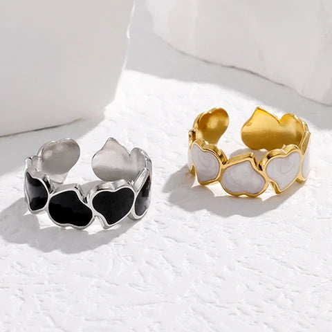 Two heart-shaped tarnish-free rings, one silver and one gold, on a light background