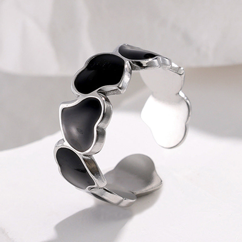 Silver tarnish-free ring with black heart-shaped stones on a white background