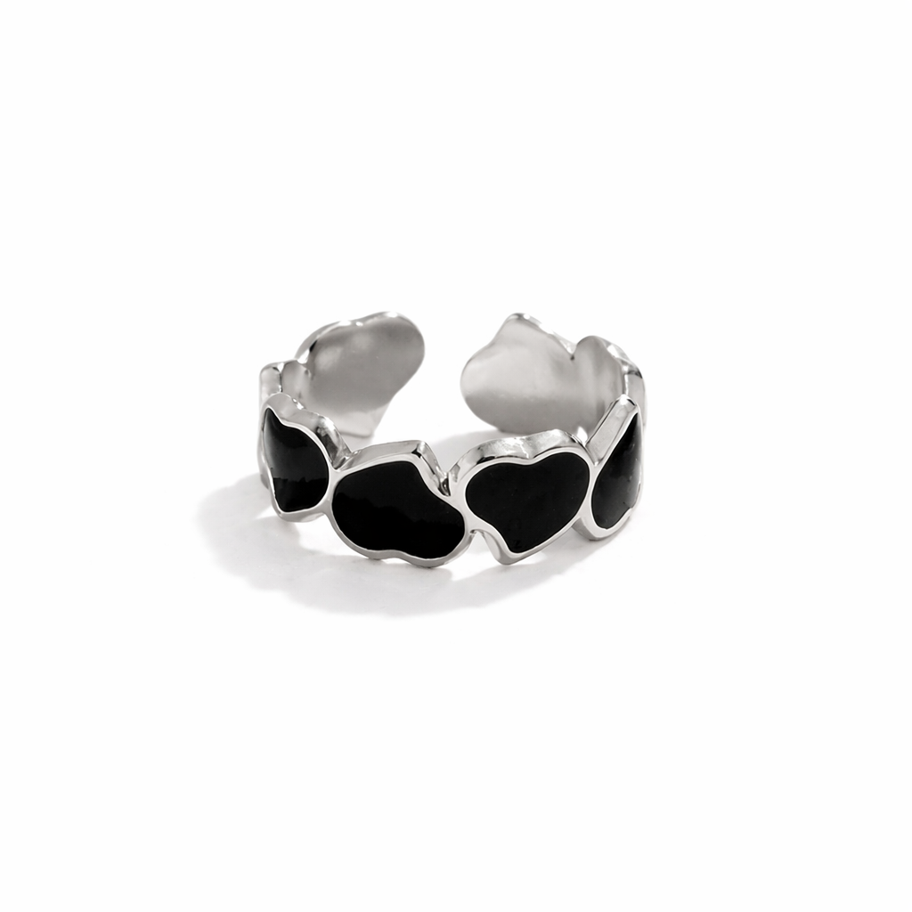 Silver ring with black heart-shaped stones on a white background