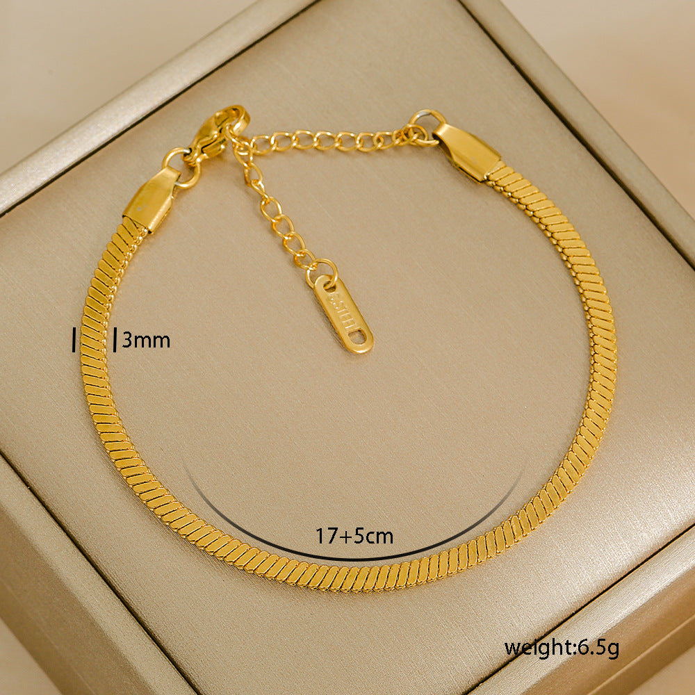 Gold bracelet with measurements on a beige background