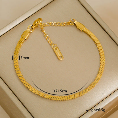 Gold bracelet with measurements on a beige background
