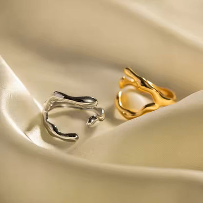 Gold and silver open rings on a beige fabric background