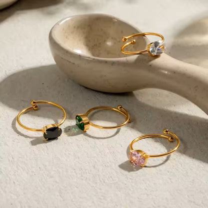 Gold rings with gemstones on a textured surface