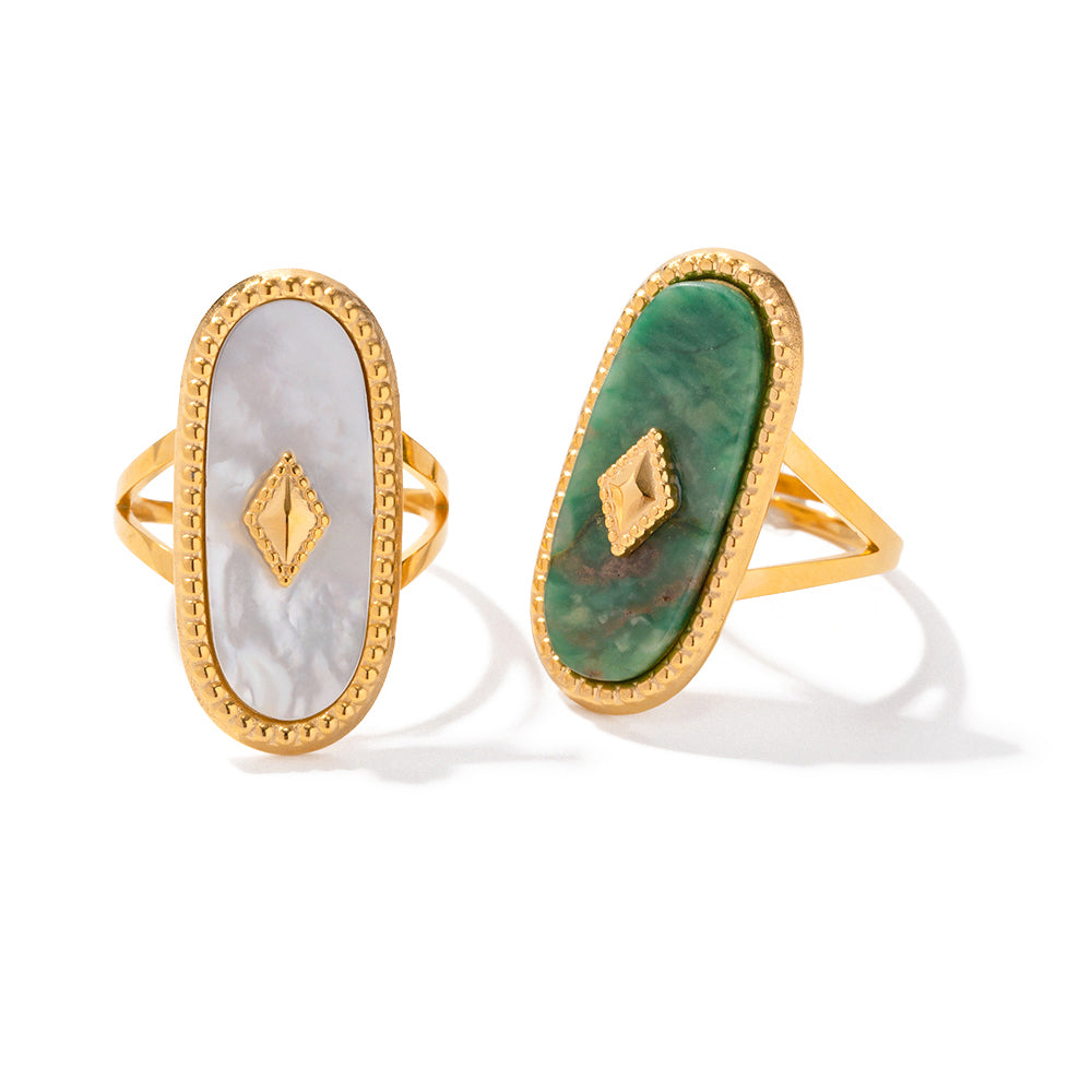Two gold waterproof rings with different colored stones on a white background