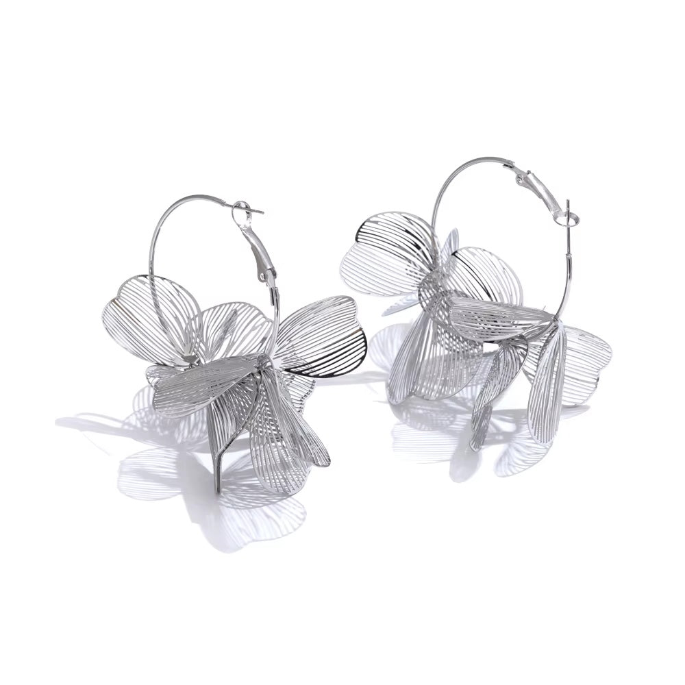 Silver floral hoop earrings on a white background