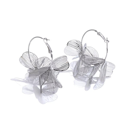 Silver floral hoop earrings on a white background