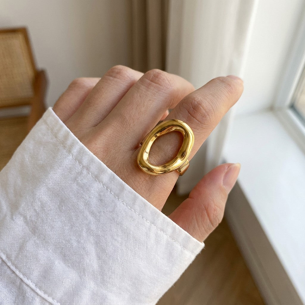 a hand with a chunky round gold waterproof ring