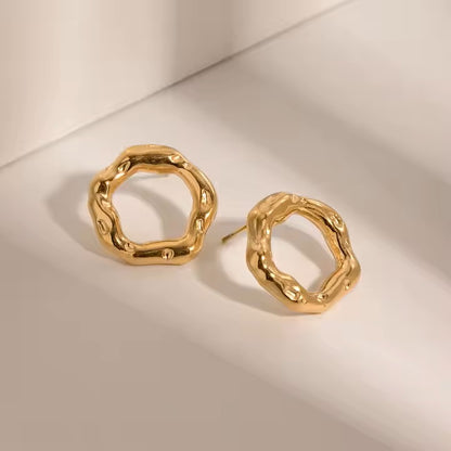 Gold stainless steel hoop earrings on a beige background